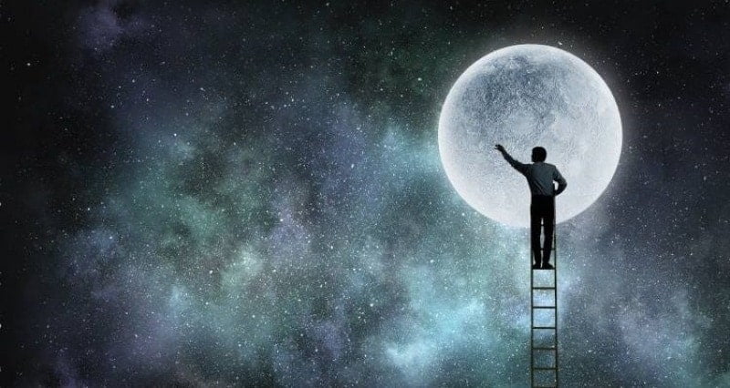 Άνθρωπος σε σκάλα που φτάνει στο φεγγάρι.